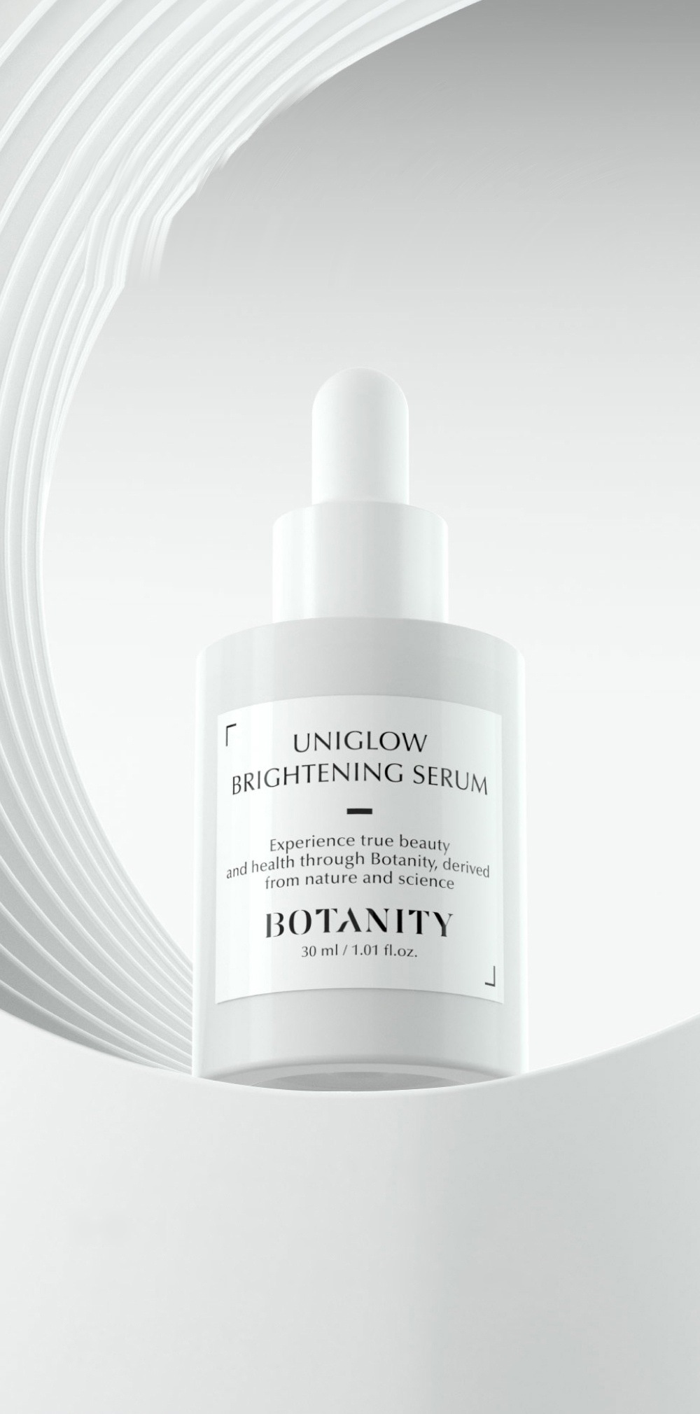 은회색 동심 곡선 벽 앞에 선 흰 스포이트 세럼 병 정면 — 라벨 UNIGLOW BRIGHTENING SERUM, BOTANITY, 30 ml / 1.01 fl.oz.